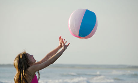teenage girl playing volleyball with beach ball at the beach