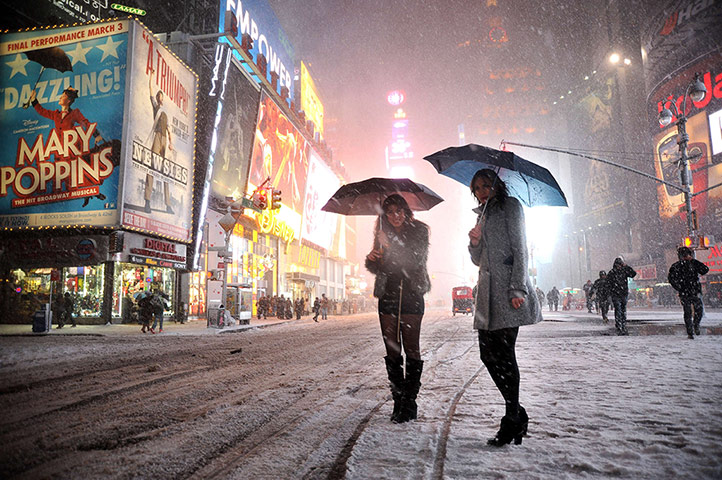 US snow: Two girls look for a taxi in the snow in Times Square