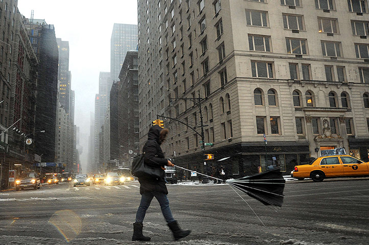  A woman loses her umbrella in New York during a storm which brought heavy snow to the densely populated north-east corridor
