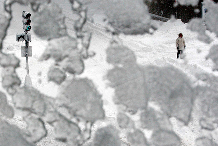 saturday snow: A woman is seen through a snow covered window during a blizzard in Boston