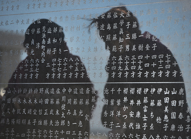 Japan anniversary: Two elderly women are reflected in a monument