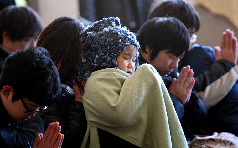 Japan anniversary: Children pray during a memorial ceremony