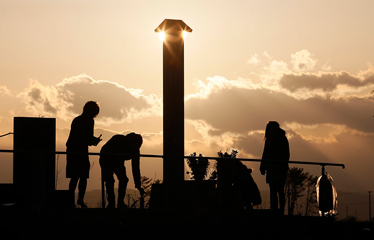 Japan anniversary: People lay floral tributes in front of a memorial at Arahama