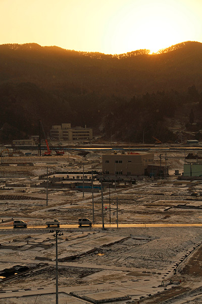 Japan anniversary: Cars stop at a traffic signal in a snow-covered deserted port