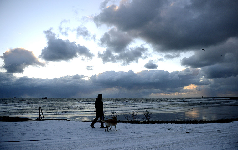 Spring snow: A man walks his dog in Tynemouth, Tyne and Wear