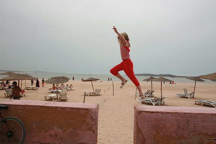 Inpics-leap: girl dressed in red trousers leaping between wall sections