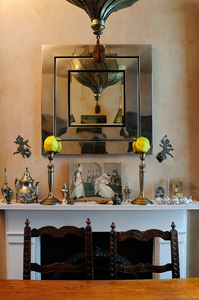 Homes - moroccan home: shot of mirror above fireplace with wooden table and chair