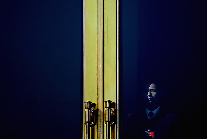 24 hours in pictures: A soldier guards behind an entrance door of the Great Hall of the People