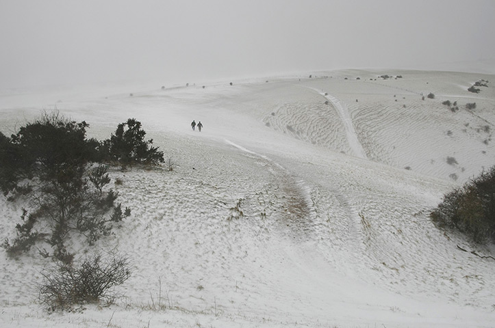 Spring snow: Two men walk in the snow at Devils Dyke