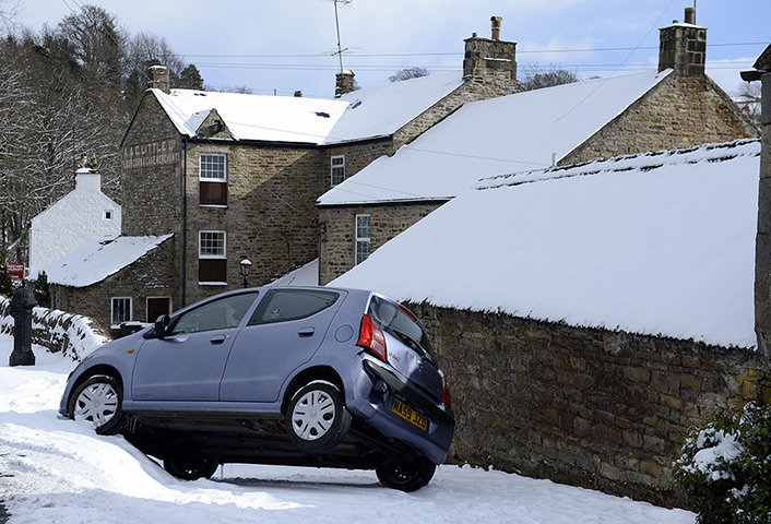 Spring snow: A car balances on two wheels after misjudging a corner