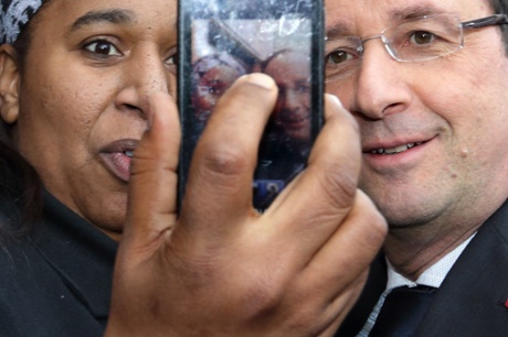 A woman takes her picture with François Hollande as the French president visits Gresilles, in the Socialist stronghold of Dijon.