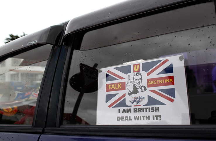Falkland Islands: A car passes the Town Hall with a sign on the window in Stanley