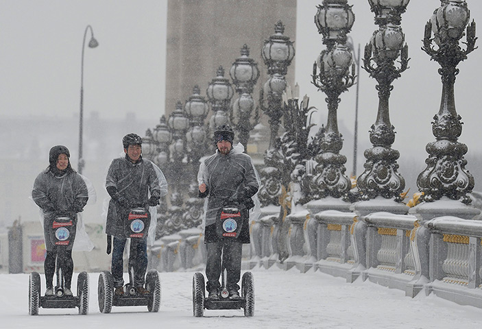 Europe snow: People ride segways along a snow-covered Alexandre III bridge
