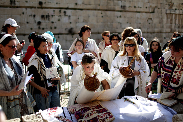 24 hours in pictures: An Israeli Jewish woman lays down a Torah scroll
