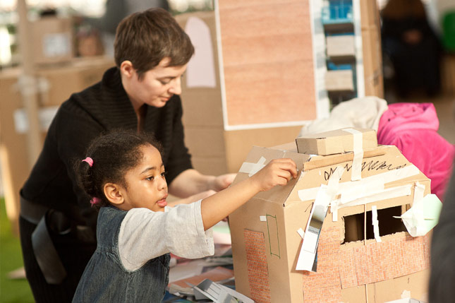 catalyst1: Small child and guardian building cardboard house