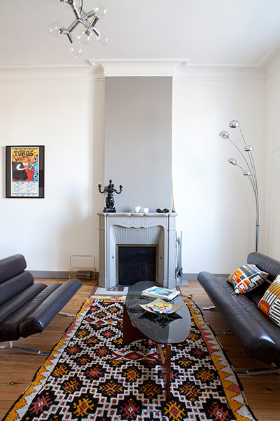 Homes - Fifties Scent: room with grey fireplace and african rug