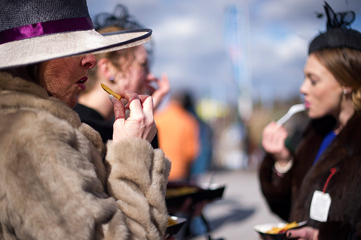 Cheltenham day 2: Woman eating chips at the Cheltenham Racing festival 2013