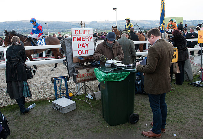 Cheltenham day 2: A punter waits to get paid out after the 5th race