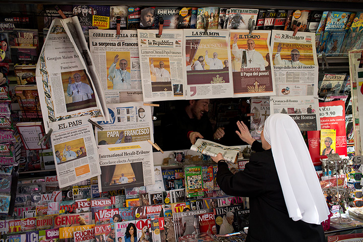 Pope Francis first day: A nun buys a newspaper with the front page of Pope Francis, at a newsstand