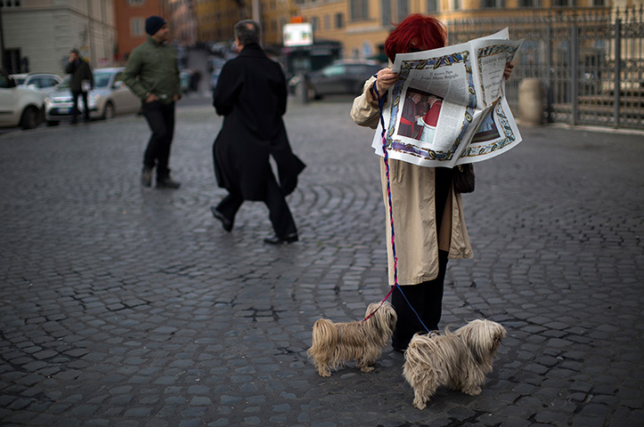 Pope Francis first day: A woman reads a newspaper showing the news of the election of Pope Francis