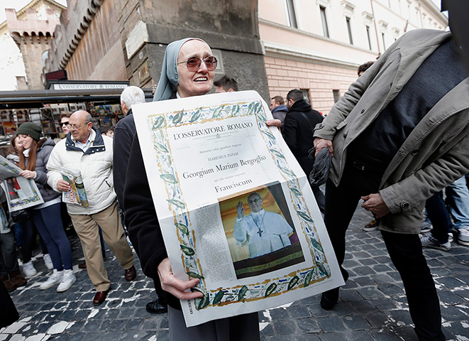 Pope Francis first day: nun shows a front page of a paper with the newly elected Pope Francis