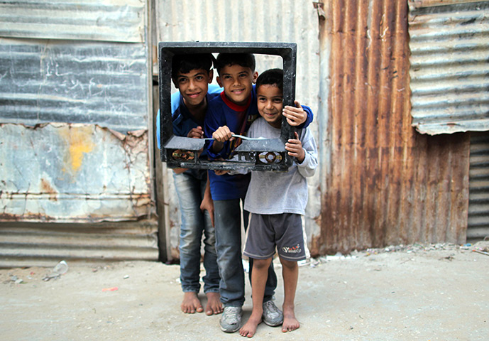 24 hours: Gaza City, Gaza Strip: Three Palestinian boys pose inside a tv