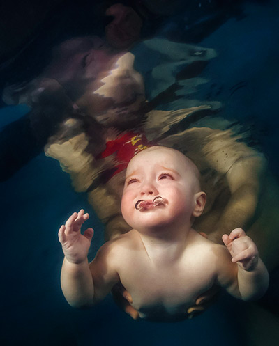24 hours: Kiev, Ukraine: A baby swims in a swimming pool