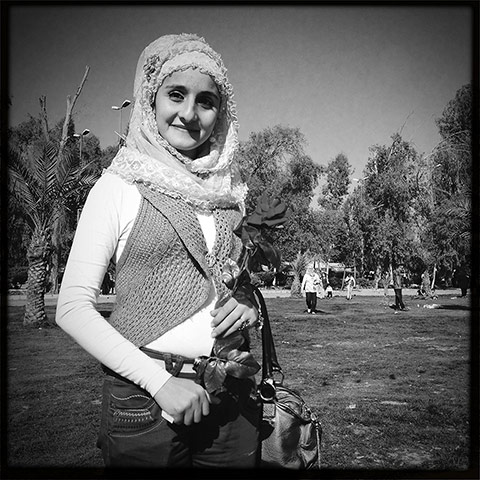 Baghdad: A young woman holds a rose n the Zawara amusement park