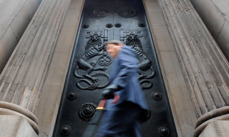 A man passes a doorway at the Bank of England in the City of London