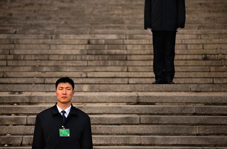 24 hours in pictures: Security guards stand on the steps of the Great Hall of the People 