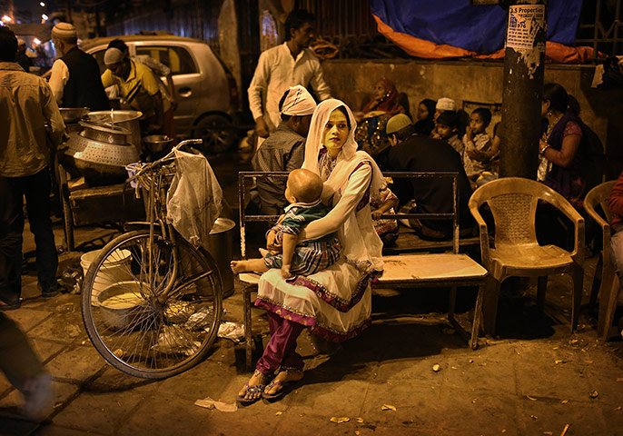 20 Photos: An Indian Muslim woman holds her child