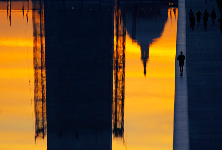 24 hours: Early morning joggers run next to the Reflecting Pool in Washington