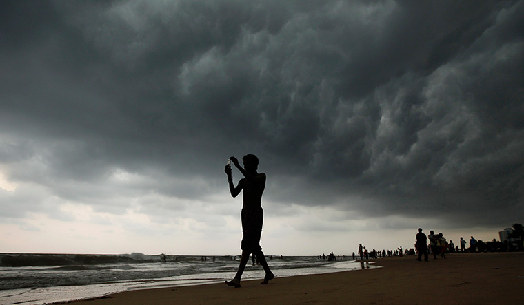 24 hours: Colombo, Sri Lanka: A man takes a picture with his mobile phone on a beach