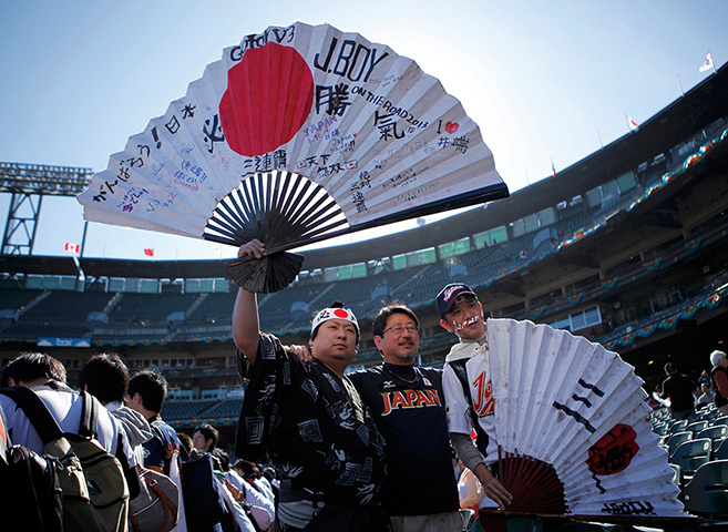 24 hours: San Francisco, US: Fans of Japan's team wave large paper fans