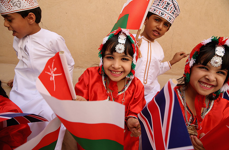24 hours: Nizwa, Oman: Young children wave flags as Prince Charles visits