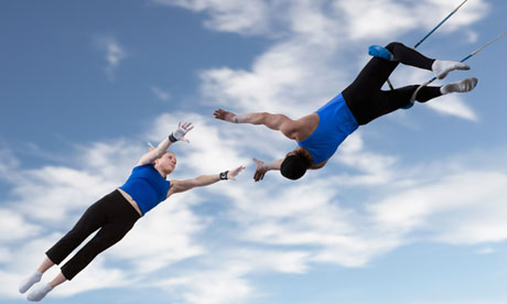 Acrobats catching each other in the air