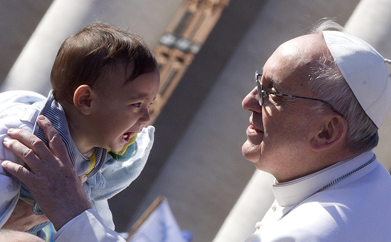 Inaugural Mass: Pope Francis blesses a child as he arrives in St Peter's square 