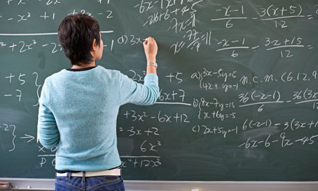 Teacher Writing Math Problem on Blackboard