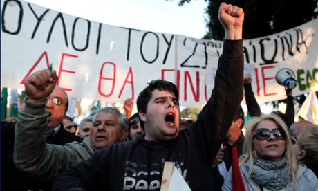 Protesters chant slogans outside the Cypriot parliament against a crucial parliamentary vote on a plan to seize a part of depositors' bank savings, in central Nicosia, Tuesday, March 19, 2013.