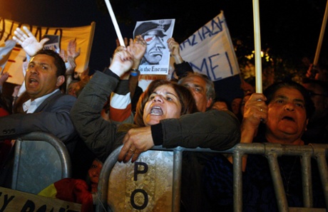 Protestors shout slogans during a rally against a tax levy on deposits, in front of the Cyprus parliament in Nicosia, Cyprus, 19 March 2013.