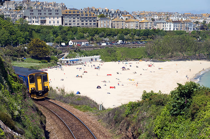 Railways: Train leaving Porthminster and Porthminster beach in St Ives ,Cornwall