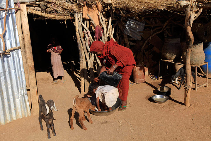 Water in Sudan: a woman washes her child