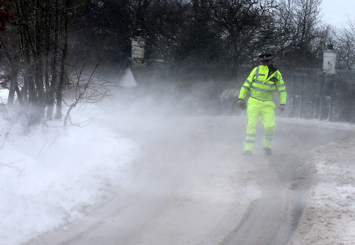 Uk snow update: A police officer struggles in the wind and snow