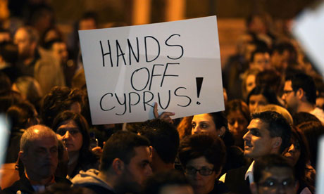 A Cypriot holds a placard outside parliament in Nicosia