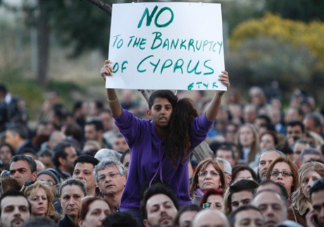 Bank employees afraid of losing their jobs, a young woman holding a poster which reads 'No to the bankruptcy of Cyprus', protest outside the Ministry of Finance in Nicosia, Cyprus, 23 March 2013.