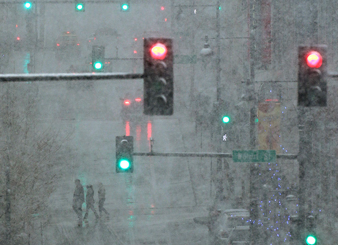 24 hours: Pedestrians cross a snowy street in Kansas City