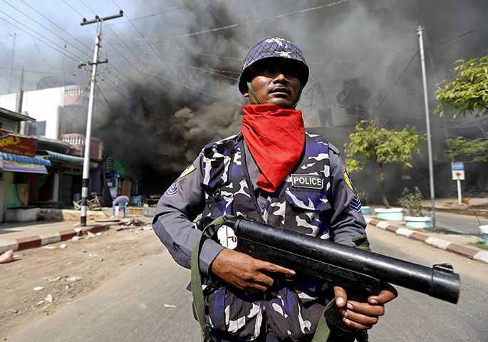 Burma violence: 22 March: A riot police officer stands guard