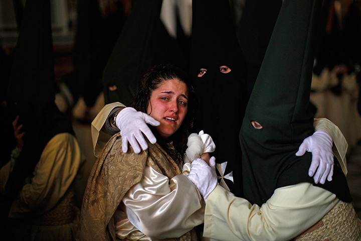 24 hours in pictures : A penitent cries as she is comforted by others 