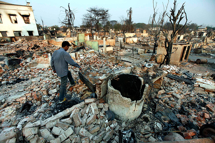 Burma violence: A man walks among debris of buildings