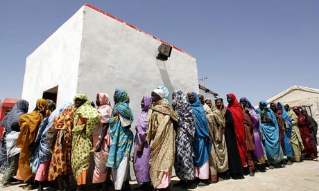 Displaced Sudanese women wait in line fo